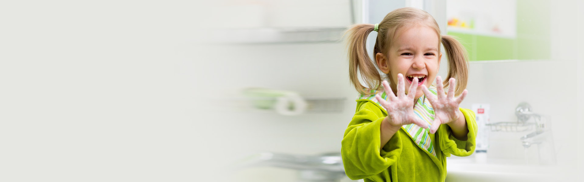 Smiling child showing clean soapy hands after handwashing